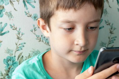 Çocuklar, dijital teknoloji ve internet konsepti, çocuk oyun oynuyor veya kafede otururken dijital akıllı telefondan internette sörf yapıyor.