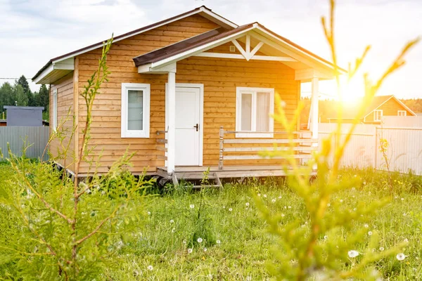 Pequeña casa de marco de madera con solarium y ventanas blancas y puerta como residencia de campo en un día soleado de verano —  Fotos de Stock