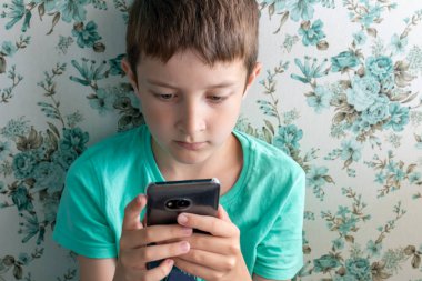 Çocuklar, dijital teknoloji ve internet konsepti, çocuk oyun oynuyor veya kafede otururken dijital akıllı telefondan internette sörf yapıyor.