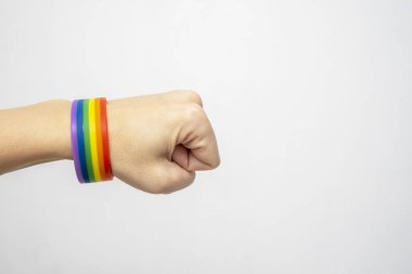 Igbt gökkuşağı takan bir el gay gururu bilezik beyaz arka plan fotokopi alanı.