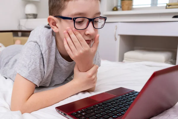 Niño Con Gafas Acostado Cama Usando Una Computadora Portátil Escribiendo —  Fotos de Stock