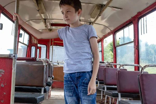 他是个10岁的男孩 坐的是老式大巴 他很伤心 因为他的生活条件差 大巴在肮脏的乡间路上行驶 — 图库照片