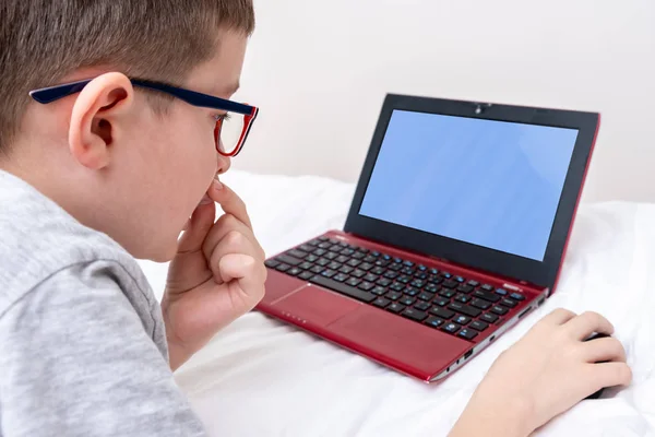 Menino Usando Óculos Deitado Cama Usando Laptop Digitando Texto Teclado — Fotografia de Stock