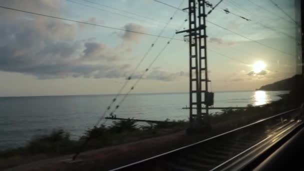 A naplemente romantikus ég a tenger felett táj, kilátás az ablakból egy mozgó vonat, utazás, utazás és nyaralás koncepció — Stock videók