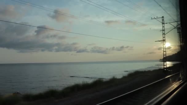 The sunset sky over the sea landscape, view from the window of a moving train, travelling, journey and vacation concept — Stock Video