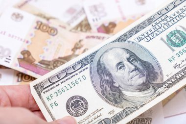 Bir el, Rus rublesi, finansal kriz ve tasarruf konsepti için para seçerken bize dolar banknotları tutuyor..