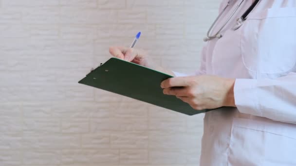 Femme médecin méconnaissable écrivant un diagnostic, cas d'antécédents médicaux sur un tableau de prescription — Video