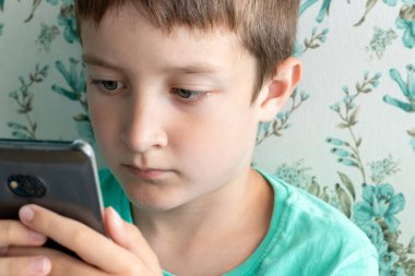 Arkadaşlarıyla sosyal ağlarda ciddi yüz sohbeti yapan genç bir çocuk, online iletişim konsepti..