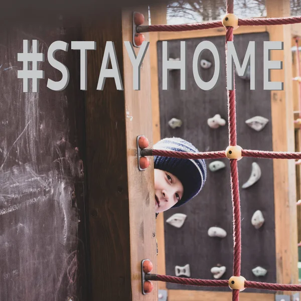 Stay home and quarantine concept. A portrait of a 10 year old boy outdoors with emotional face and a sign meaning not to go outside to feel safe