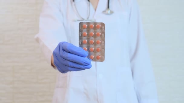 赤い丸薬を示す青い手袋の医師 ブリスターのカプセル 病気の治療と処方コンセプト — ストック動画