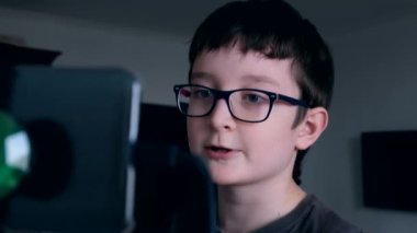 Günlük antrenman yapan bir çocuk, koşu bandında yürüyor ve iletişim kuruyor, akıllı telefonla arkadaşlarıyla konuşuyor, karantina süresince sosyal bağlantılar kuruyor.