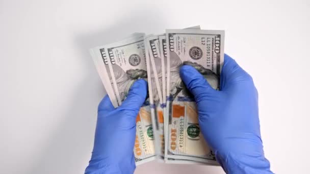 Manos de médico corrupto en guantes azules contando dinero, médico aceptando sobornos y contando billetes de dólar de cerca, tratamiento caro y concepto de medicina — Vídeo de stock