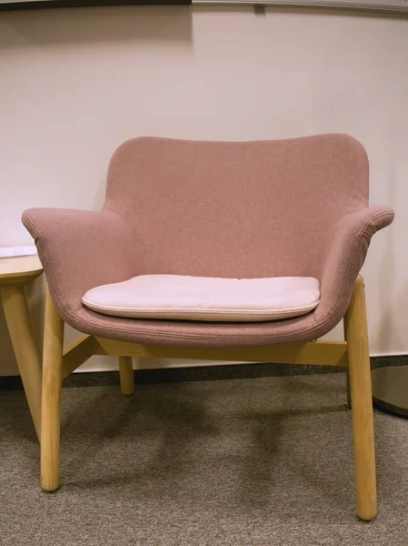 オフィスの真ん中に座って 現代ピンク椅子に座って — ストック写真