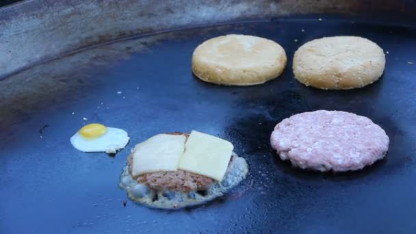 Cook utilise un chalumeau pour faire fondre le fromage sur une escalope de viande. Chef fait fondre le fromage sur un hamburger à l'aide d'une torche . — Video