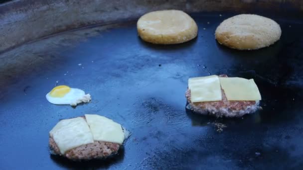 Cuocere utilizza una fiamma ossidrica per sciogliere il formaggio su una cotoletta di carne. Uovo fritto in una grande padella — Video Stock