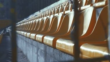 Bir boş Stadyumu arkasında bir metal çit, 4k Sarı sandalyeler