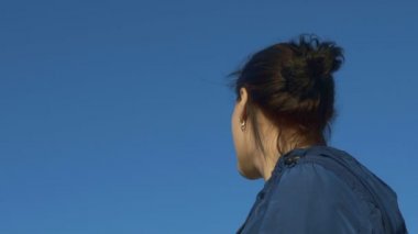 Gülümseyen ve elini sallayarak genç kadının biri, ağır çekim, 120 fps arıyor