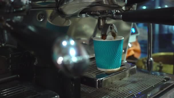 Kaffeemaschine gießt Kaffee in die blaue Papptasse. — Stockvideo