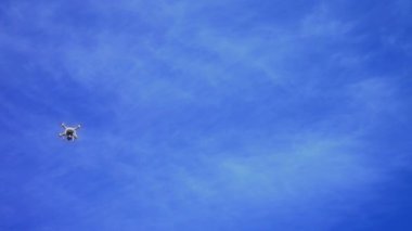 Helikopter, mavi gökyüzü, beyaz bulutlar ile mavi gökyüzüne karşı Quadrocopter uçan uçak