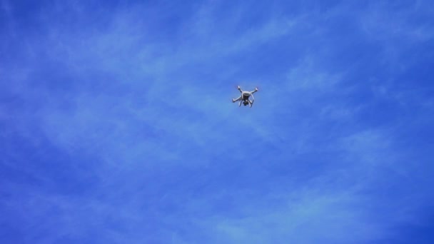 Helikopter repül a kék égen, szemben a kék ég, fehér felhők Quadrocopter drone — Stock videók