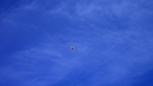 Copter, drone volando en un cielo azul, Quadrocopter contra el cielo azul con nubes blancas — Vídeo de stock