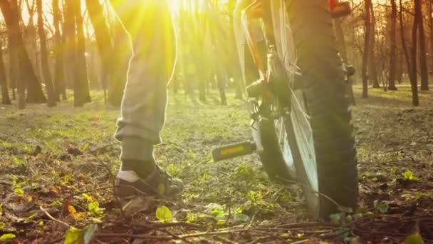 Il bambino impara ad andare in bicicletta nel parco, al tramonto, al rallentatore — Video Stock