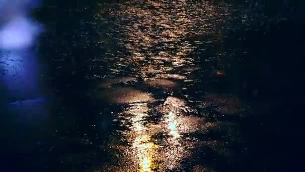 Cars drive into large puddles on the night road in the city, spray puddles scatter from under the wheels of the car — Stock Video