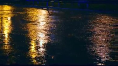 Şehrin sprey gece yolda otomobil sürücüsü büyük su birikintileri içine dağılım tekerlekleri arabanın altından su birikintileri