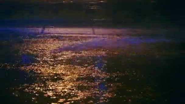 車が大きな水たまりに都市、スプレーの夜道路の水たまり散布車の車輪の下から — ストック動画