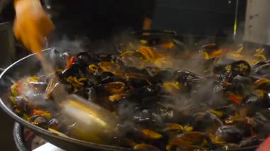 Şef paslanmaz çelik tavada deniz ürünleri istiridye Pişirme Kızartma