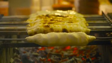 Gürcü geleneksel çanak - khachapuri, pasta peynirli bir şiş üzerinde dönen ızgarada kızartılmış