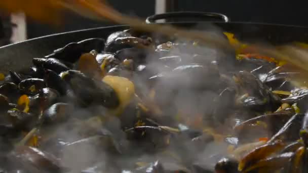 Chef está friendo mariscos en una sartén de acero inoxidable, cocinando ostras — Vídeos de Stock