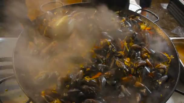 Chef está fritando frutos do mar na panela de aço inoxidável, cozinhar ostras — Vídeo de Stock