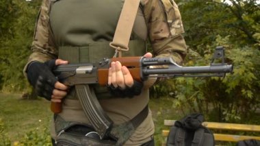 Bir silah onun elinde otomatik tüfek olan asker üniformalı bir adam