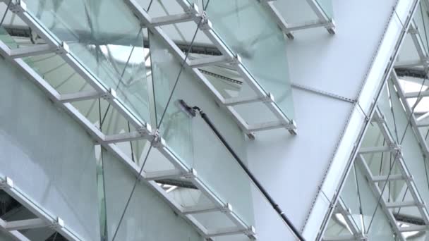 Lavagem de janelas com uma escova com uma alça longa, limpeza de superfícies de vidro no estádio, câmera lenta — Vídeo de Stock