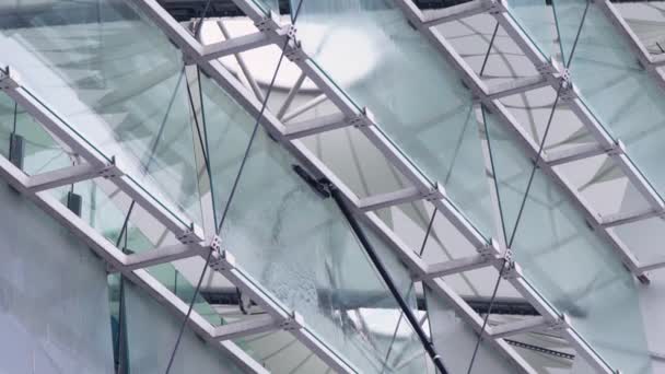 Wassen van ramen met een borstel met een lange steel, reiniging van glazen oppervlakken in het stadion, slow-motion — Stockvideo