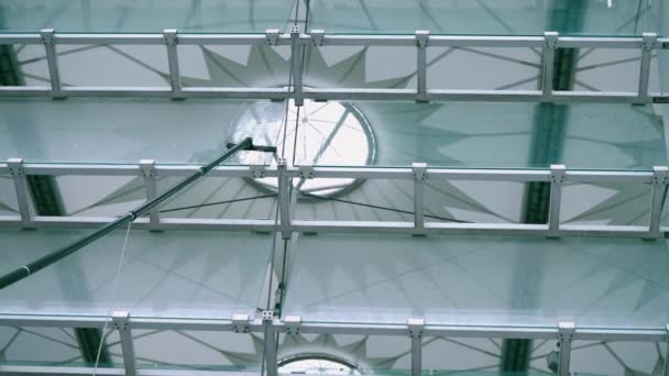 Lavando ventanas con un cepillo con mango largo, limpiando superficies de vidrio en el estadio — Vídeos de Stock