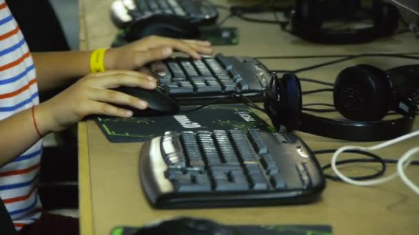 Мальчик играет в компьютерные онлайн игры, Ребенок в компьютерном клубе — стоковое видео