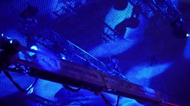 Bir televizyon programı çekilirken musluktaki video kamera. Canlı konser. Kameranın tavanın altındaki seyircilerin üzerindeki hareketi. Yüksekten ateş ediyorlar. Sahne ışıkları sahneyi aydınlatır. Mavi ışık.