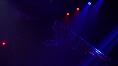 Bir televizyon programı çekilirken musluktaki video kamera. Canlı konser. Kameranın tavanın altındaki seyircilerin üzerindeki hareketi. Yüksekten ateş ediyorlar. Sahne ışıkları sahneyi aydınlatır. Mavi ışık.