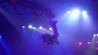 Bir televizyon programı çekilirken musluktaki video kamera. Canlı konser. Kameranın tavanın altındaki seyircilerin üzerindeki hareketi. Yüksekten ateş ediyorlar. Sahne ışıkları sahneyi aydınlatır. Mavi ışık.