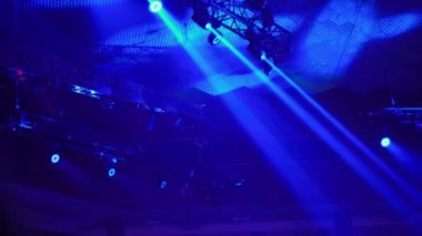 Bir televizyon programı çekilirken musluktaki video kamera. Canlı konser. Kameranın tavanın altındaki seyircilerin üzerindeki hareketi. Yüksekten ateş ediyorlar. Sahne ışıkları sahneyi aydınlatır. Mavi ışık.