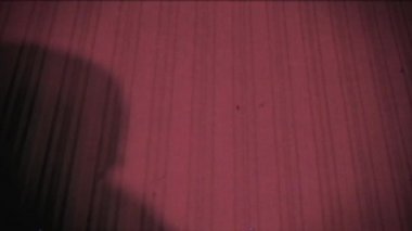 Bağbozumu etkisi. Bir adam kurbanını bıçakla öldürür. Arşiv. Geçmişe dönüş. Eski film. Cinayeti. Duvardaki suçlunun gölgesi. Cadılar Bayramı.