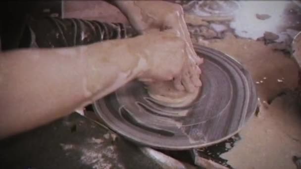 ヴィンテージ効果 陶芸家は女性に粘土料理を作るように教える グリッチ家族のビデオアーカイブレトロだ男は女の手を取る 陶芸家は陶芸家の車輪の上に粘土の瓶を作る — ストック動画