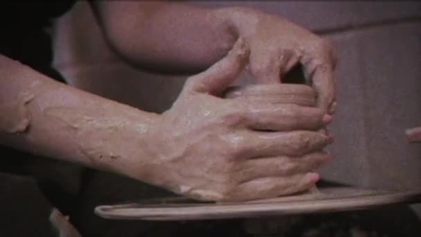 复古效果 一个陶工教一个女人做粘土盘 Glitch 家庭视频档案 男人牵着女人的手 陶瓷匠在陶工的轮子上做了一壶粘土 家庭企业 — 图库视频影像