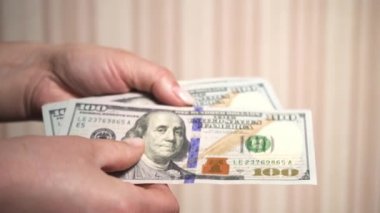 100 dolarlık banknotlar kadınların elinde. Sayıyorum, para sayıyorum. Zenginlik. Çok para. Finansal durgunluk, durgunluk, kriz, iş kazası ve ekonomik çöküş kavramı.