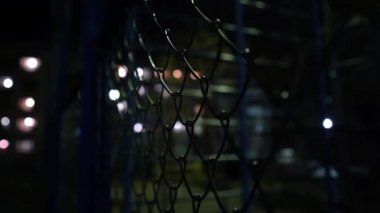 Metal ağ. Geceleri fenerlerin ışığında boş basketbol sahası. Metal bir ağ vasıtasıyla açık hava basketbol sahası manzarası. Sokak sporu. Hapis. Sonuç. Kapalı alan.