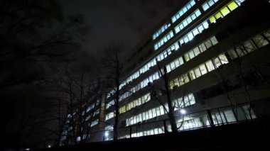 Geceleri ofis binası. Gece yarısı pencereleri açık olan bir ofis binasının dışında. Kampüs. Bilgi işlem şirketi. Modern iş merkezi, dış görünüş.