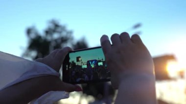 Bedava konser. Mutlu insanlar inanılmaz bir müzik konseri izliyorlar. Neşeli hayranlar zıplıyor ve ellerini kaldırıyor. Taraftarlar akıllı telefondan konser çekiyorlar. Canlı konser.