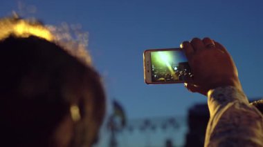 Bedava konser. Mutlu insanlar inanılmaz bir müzik konseri izliyorlar. Neşeli hayranlar zıplıyor ve ellerini kaldırıyor. Taraftarlar akıllı telefondan konser çekiyorlar. Canlı konser.